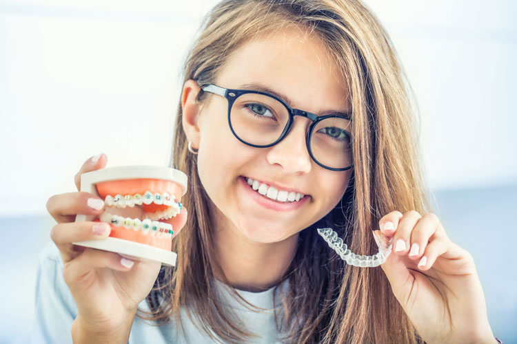 Adolescente tenant des aligneurs Invisalign transparents